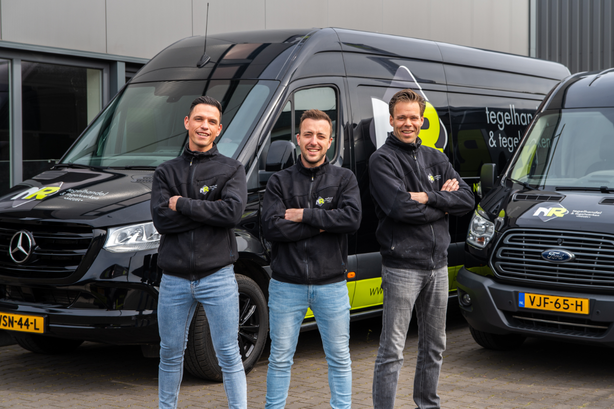 Team van NR Tegelwerken voor de auto's van NR Tegelwerken geposeerd